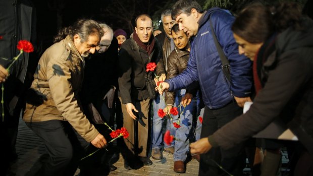 Citizens leave carnations as they gather near the site of the explosion in the historic Sultanahmet district in Istanbul, on Tuesday.