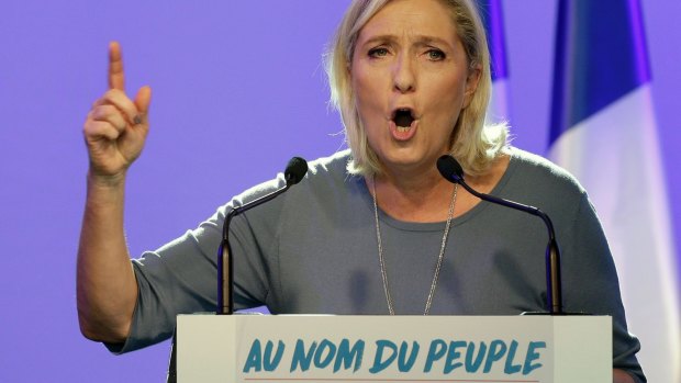 France's far-right National Front leader Marine Le Pen speaks behind the slogan "In the name of the people".
