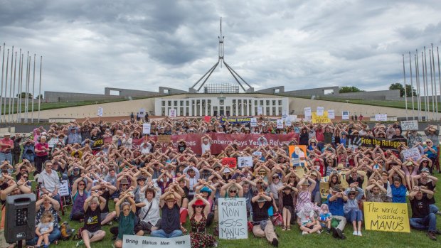 Protesters at Parliament House in Canberra cross their arms in solidarity with the Manus Island detainees.