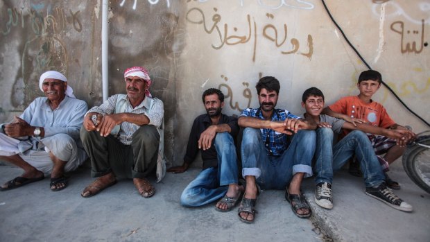 People rest in central Tal Abyad, which was taken from Islamic State last week.