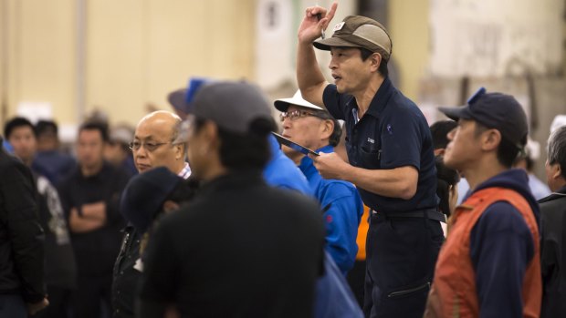 An auctioneer calls out bids during the final tuna auction at Tsukiji Market.