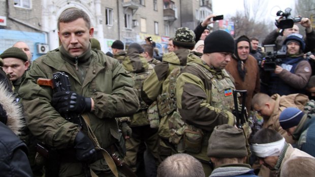 Leader of the self-declared Donetsk People's Republic Alexander Zakharchenko (left) stands next to kneeling captive Ukrainian soldiers at a bus stop where 13 people were killed in a trolleybus shelling in Donetsk, eastern Ukraine.