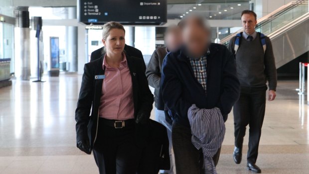 The two suspects, with their faces obscured here, arrive at Sydney Airport, escorted by police.