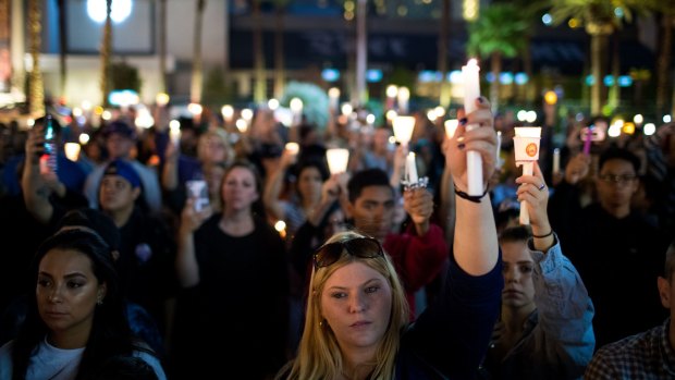 Mourners hold a vigil in Las Vegas after 58 people were killed.