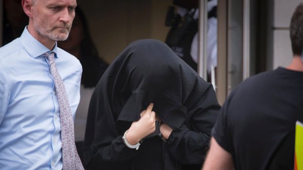 A person is led away in handcuffs during a police operation at an address in Barking, east London.