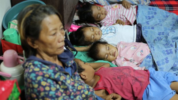 Preparing: Filipino children sleep as families seek refuge at a school used as an evacuation centre.