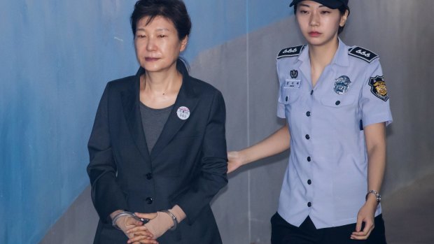 Park Geun-hye, former president of South Korea, is escorted by a prison officer as she arrives at court in June. 