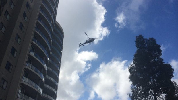 A police helicopter flies over a crime scene set up at the Monarco Estate complex in Westmead after a woman's body was found nearby.