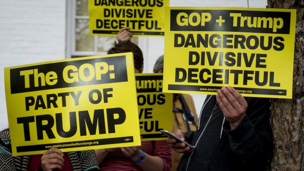 Demonstrators protest Trump and the Republican party outside its headquarters in Washington, DC.