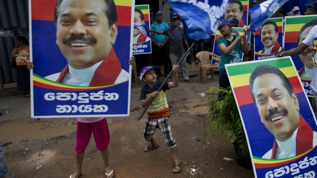 Supporters of Sri Lanka's former president and parliamentary candidate Mahinda Rajapaksa display his posters to mark conclusion of voting in Colombo.
