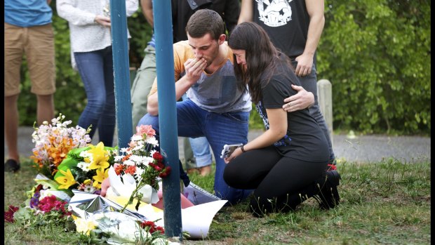 Masa Vukotic's boyfriend, Tim, is comforted by friends as he leaves a tribute to the 17-year-old.