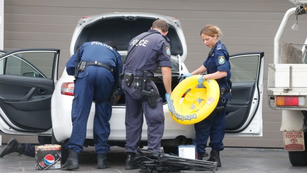 Police scour through cars at a Merrylands house in 2015 as part of a FPO search.