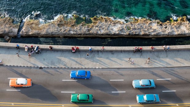 Cars speeding along the Malecon in Havana.
