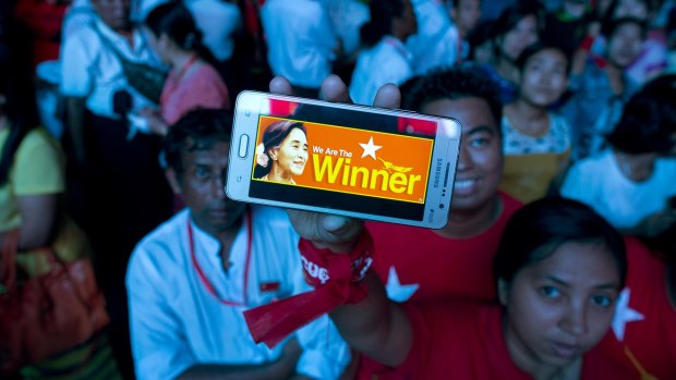 A supporter of Myanmar's National League for Democracy party displays her mobile phone with a picture of Aung San  Suu Kyi as they gather to celebrate election results in Yangon, in November.