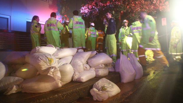 Emergency services survey the damage to homes on Collaroy Plateau and prepare sandbags for the rising King tides.