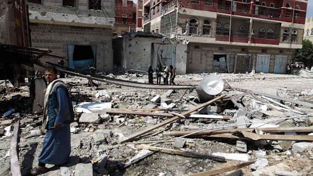 Shiite rebels, known as Houthis, stand in the rubble of a food storage warehouse destroyed by a Saudi-led airstrike in Sanaa on Monday. 