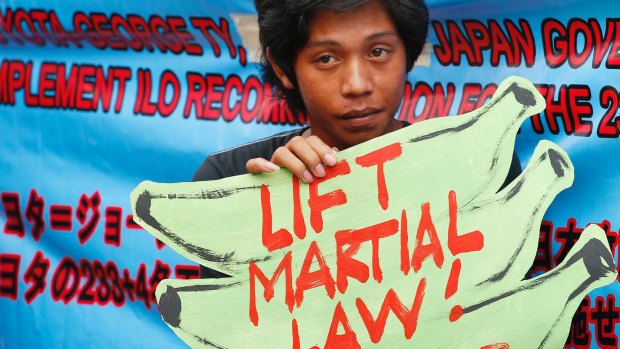 A protester holds a placard to protest the extension of martial law on Mindanao island in southern Philippines.