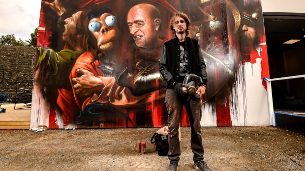Matt ''Adnate'' in front of his piece mocking the Banksy exhibition.