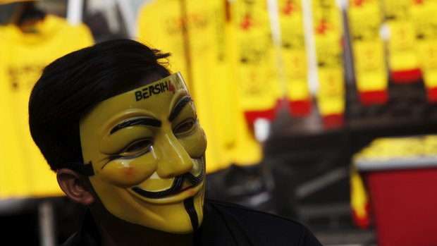 A shopkeeper wearing a pro-democracy group Bersih mask tends a stall at the Kuala Lumpur and Selangor Chinese Assembly Hall.