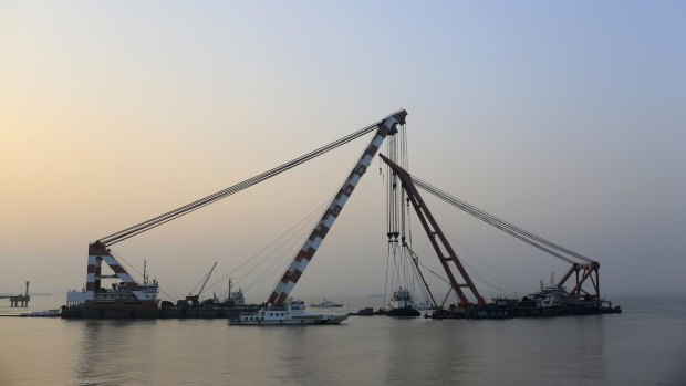 A sunken tug boat is lifted from the Yangtze River by a rescue team near Jingjiang, Jiangsu province in China.