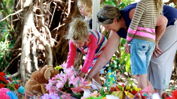 Mourners lay flowers at the memorial for eight children killed in Cairns.