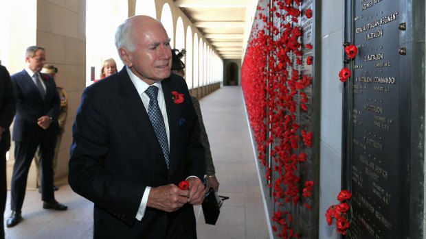 Paying tribute: Former prime minister John Howard lays a poppy at the Afghanistan Roll of Honour during the Remembrance Day ceremony at the Australian War Memorial.
