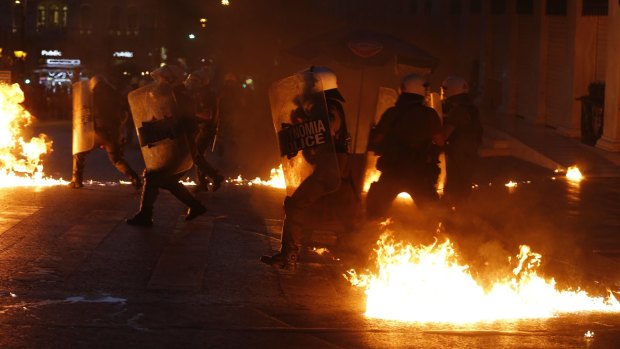 Riot police try to avoid petrol bombs during clashes with anti-austerity protesters in Athens.