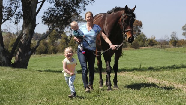 Equestrian rider Claudia Hodgson at her Wallaroo property with her children Skye, 3, Max 6 months, and her mount, 'Sandberg'.
