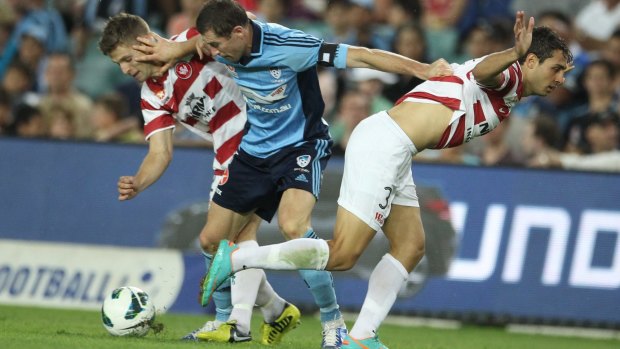 Strong feelings: Brett Emerton holds off two defenders in a 2012 Sydney derby.
