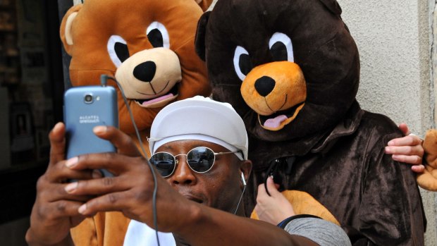 Thaddius Way takes a selfie with Rebecca, left, and Rachel Faullin, right, dressed as bears for The Stop the Florida Bear Hunt campaign protest in downtown Jacksonville.