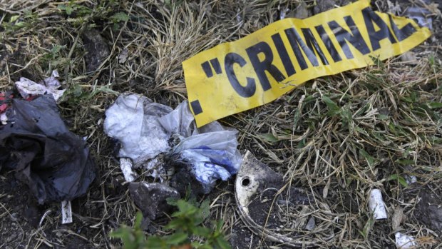 GRIM FIND: A part of a yellow police tape is seen at a garbage dump, where remains were found.