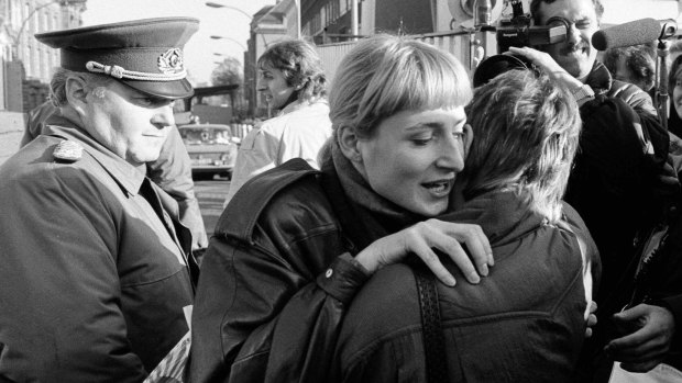 An East Berlin citizen embraces a West Berlin woman after the fall of the wall.