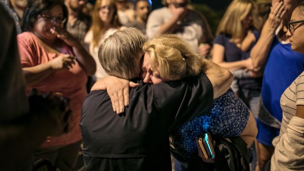 Greg Abbott consoles Ann Montgomery, a Sunday school teacher at First Baptist Church in Sutherland Springs during a candlelight vigil for the victims of the fatal shooting.