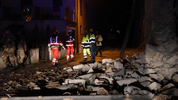 Rescuers stand by rubble in the village of Visso, central Italy.