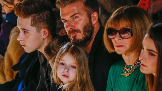 David Beckham sits next to Anna Wintour with his daughter, Harper, on his lap, and son Brooklyn during a presentation of the Victoria Beckham Fall/Winter 2015 collection during New York Fashion Week.