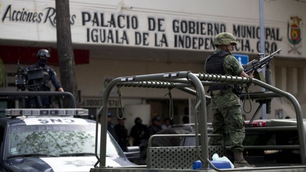 On guard: Armed vehicles in Iguala, near where 28 bodies have been found in a mass grave.