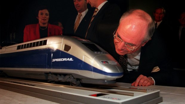 Former prime minister John Howard takes a close look at a model of a 'Speedrail', the winning tender for a proposed Sydney to Canberra service.