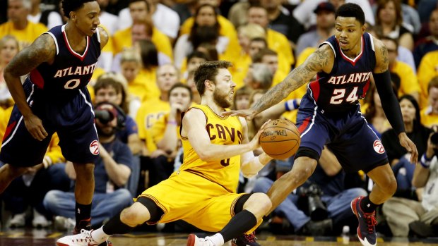 Scrapping for the ball: Matthew Dellavedova competes with Atlanta Hawks duo Jeff Teague and Kent Bazemore for possession.