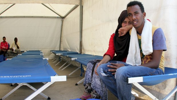 Migrants wait after disembarking from the Phoenix in Italy on Friday.