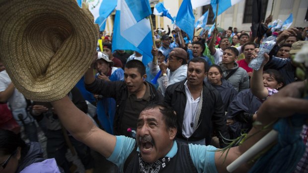 Protesters celebrate as they hear the news that Congress has voted to withdraw President Otto Perez Molina's immunity from prosecution in Guatemala City.