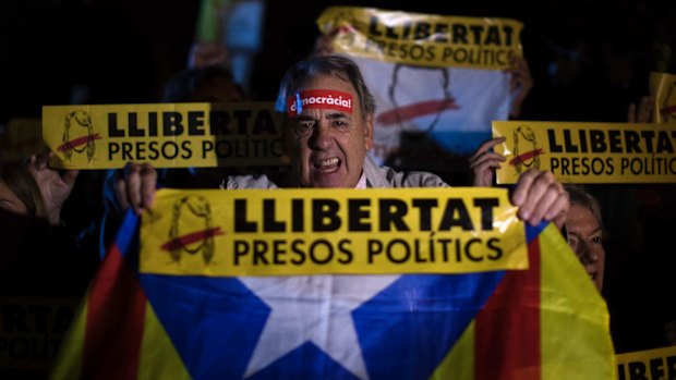 Demonstrators holding banners in Catalan reading: "Freedom for the political prisoners" gather outside the Catalonian Parliament in Barcelona on Thursday to protest against the decision of a judge to jail former members of the Catalan government.