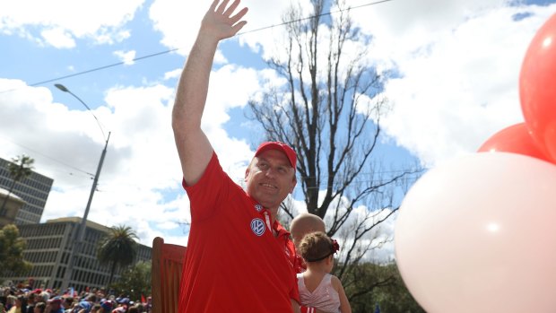 Swan coach John Longmire waves at fans.