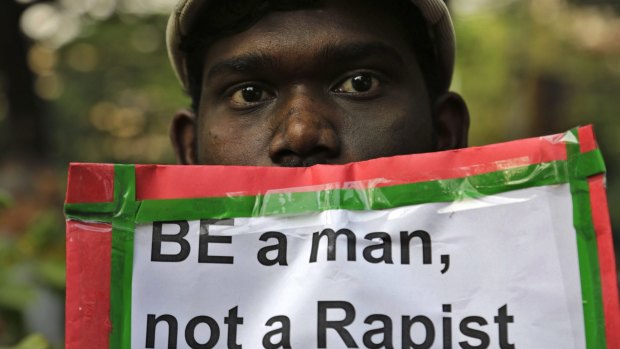 A man holds a placard as Indian Christians and others condemn the gang-rape of a nun at a Christian missionary school in eastern India.