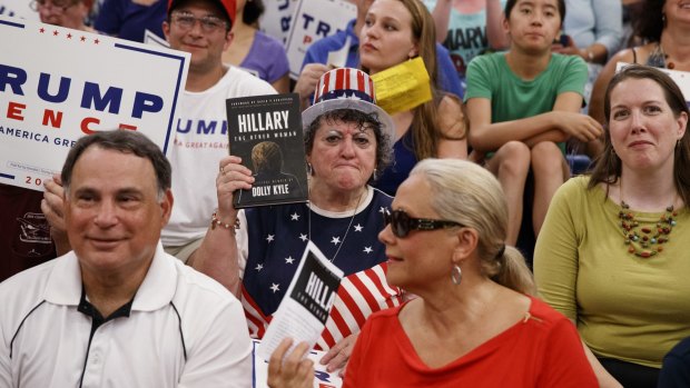 A Trump supporter holds a copy of Dolly Kyle's recently published expose on Hillary Clinton at a campaign rally in New Hampshire.