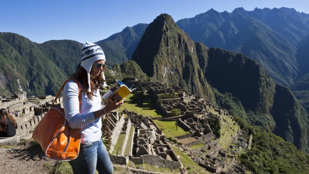 Looking deeper: A young tourist reads a guide book at Machu Picchu. 