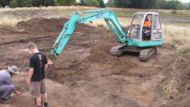 Scientist Peter White and student Jon Lushey with an excavator at the site.