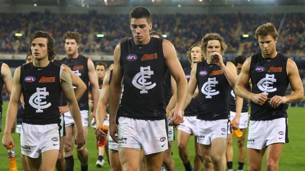 Beaten again: Carlton players leave the field after losing to the Brisbane Lions.
