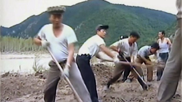 North Korean workers build levees along a river bank. North Korea is mobilising to deal with a disastrous flood.