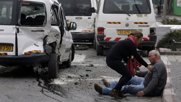 A wounded man sits on the street after a vehicle attack by a Palestinian motorist in Jerusalem in which a policeman was killed on November 5.