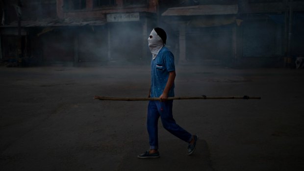 A Kashmiri protester stands in tear gas smoke during a protest in Srinagar.